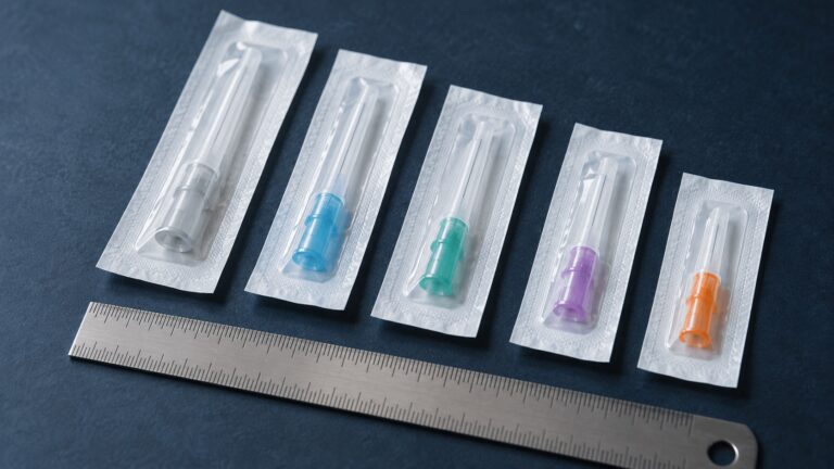 Illustration of capped needle packs beside a ruler
